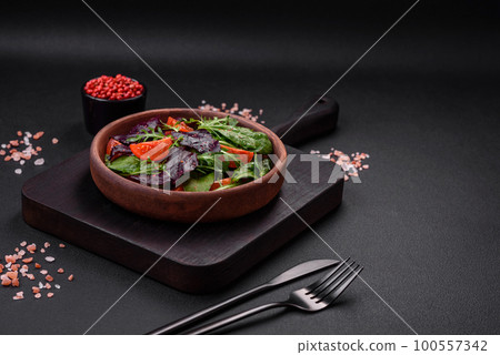 Salad of fresh cherry tomatoes, arugula, spinach and young beet leaves 100557342