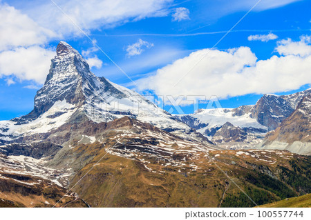 Scenic view on snowy Matterhorn mountain peak in sunny day with blue sky in Switzerland. Beautiful nature background of Swiss Alps covered with snow. Famous travel destination Scenic view on snowy Matterhorn mountain peak in sunny day with blue sky in Switzerland. Beautiful nature background of Swiss Alps covered with snow. Famous travel destination 100557744