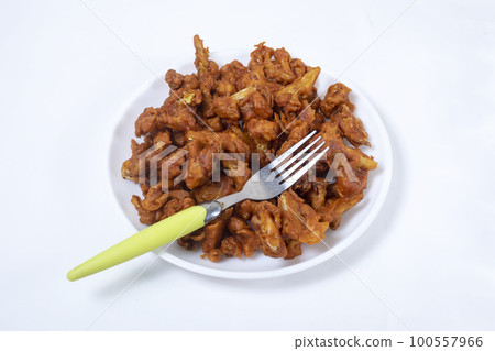 Fried Gobi Manchurian in white plate with green fork on white background. Fried Gobi Manchurian in white plate with green fork on white background. 100557966