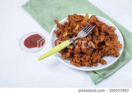 Fried Gobi Manchurian Dry with tomato sauce on white plate with green napkin. Gobi 65 is a popular Indian street food made from cauliflower florets. Fried Gobi Manchurian Dry with tomato sauce on white plate with green napkin. Gobi 65 is a popular Indian street food made from cauliflower florets. 100557967