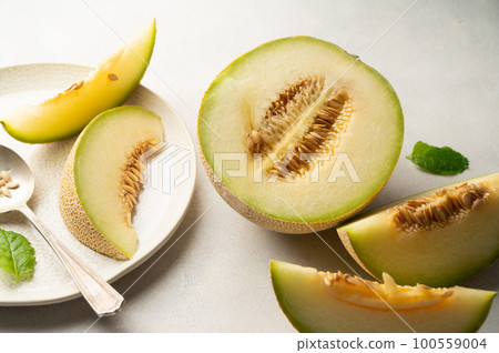 Cantaloupe, melon fruit slice over bright background.  100559004