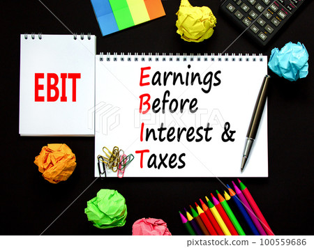 EBIT symbol. Concept words EBIT earnings before interest and taxes on white note on beautiful black background. Business EBIT earnings before interest and taxes concept. Copy space. 100559686