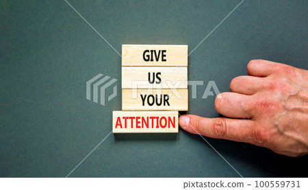 Give us your attention symbol. Concept words Give us your attention on wooden block. Beautiful grey table grey background. Motivational business give us your attention concept. Copy space. 100559731