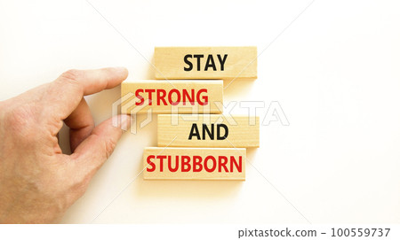 Stay strong and stubborn symbol. Concept words Stay strong and stubborn on wooden block. Beautiful white table white background. Motivational business stay strong and stubborn concept. Copy space. Stay strong and stubborn symbol. Concept words Stay strong and stubborn on wooden block. Beautiful white table white background. Motivational business stay strong and stubborn concept. Copy space. 100559737