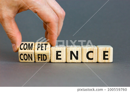 Competence and confidence symbol. Concept word Competence Confidence on wooden cubes. Businessman hand. Beautiful grey table grey background. Business competence confidence concept. Copy space. 100559760