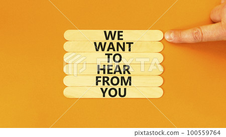 Support symbol. Concept words We want to hear from you on wooden stick. Beautiful orange table orange background. Businessman hand. Business support we want to hear from you concept. Copy space. 100559764