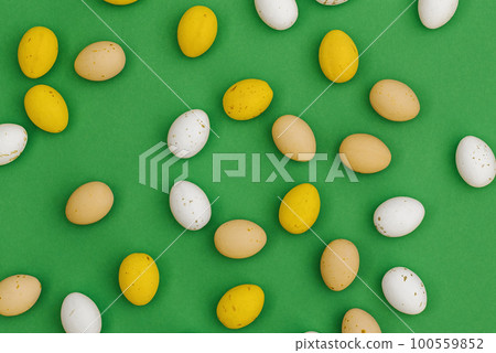 Chocolate Easter eggs on green background 100559852