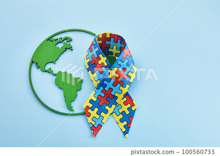 World Autism awareness and pride day or month with Puzzle pattern ribbon on blue background 100560733