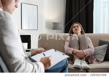 Professional psychotherapist working with patient in office 100562499