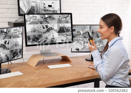 Female security guard with portable transmitter at workplace Female security guard with portable transmitter at workplace 100562862