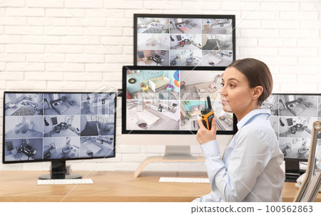 Female security guard with portable transmitter at workplace 100562863