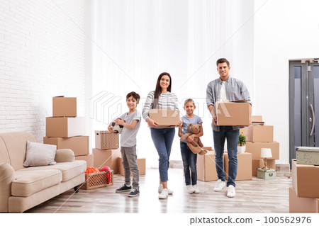 Happy family in room with cardboard boxes on moving day 100562976
