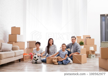 Happy family in room with cardboard boxes on moving day 100562977