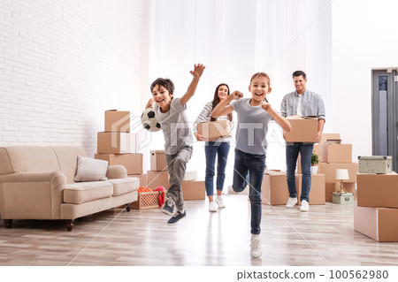 Happy family in room with cardboard boxes on moving day Happy family in room with cardboard boxes on moving day 100562980