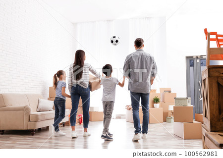 Family in room with cardboard boxes on moving day Family in room with cardboard boxes on moving day 100562981