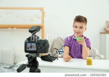 Cute little blogger with slime recording video at home 100562985