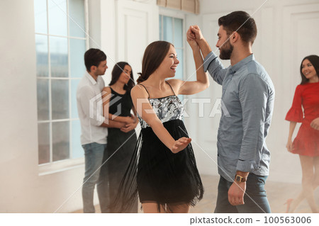 Lovely young couple dancing together at party 100563006