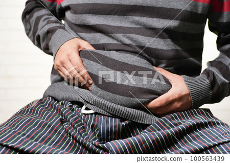 man's hand holding excessive belly fat, overweight concept 100563439