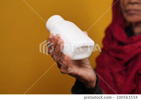 senior women holding a medical pill container  100563554