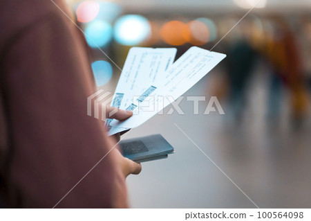Girl holds tickets, boarding passes for a flight. 100564098