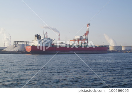 A view of a cargo ship and a steel mill loading and unloading in the Kashima Rinkai Industrial Area 100566095