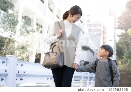 背著書包的孩子在上下學路上和媽媽說話 100568598