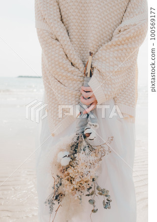 海邊拿著乾花的女人照片 100569177