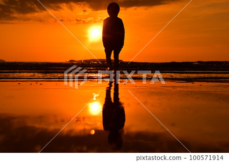 boy facing the sunset 100571914