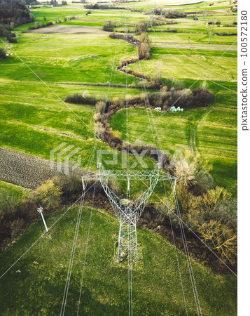 Vertical photo directly above centered on the electrical tower an electrical wires running from it across the green country side of Slovenia Vertical photo directly above centered on the electrical tower an electrical wires running from it across the green country side of Slovenia 100572180
