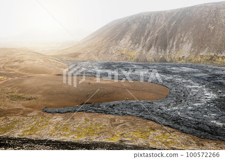 Aerial view of cooled down black volcanic lava rocks and red soil in Icelandic highlands near Geldingadalir volcano Aerial view of cooled down black volcanic lava rocks and red soil in Icelandic highlands near Geldingadalir volcano 100572266