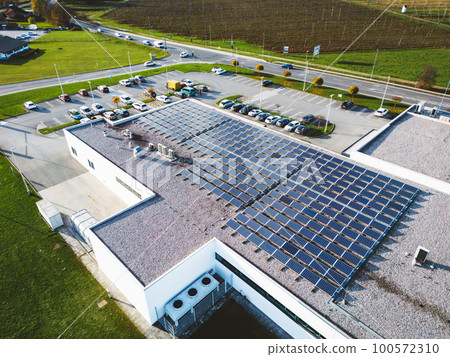 Modern shopping centre building with rooftop covered in solar panels 100572310