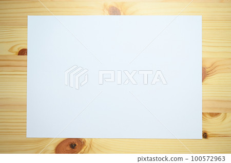 white paper on wooden table, paper textured background white paper on wooden table, paper textured background 100572963