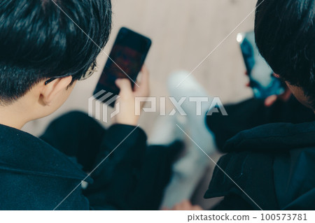 A picture of a male college student touching a smartphone in the park A picture of a male college student touching a smartphone in the park 100573781