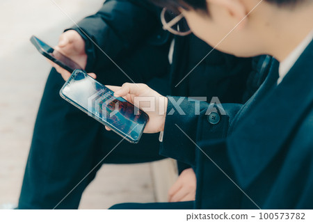 A picture of a male college student touching a smartphone in the park A picture of a male college student touching a smartphone in the park 100573782
