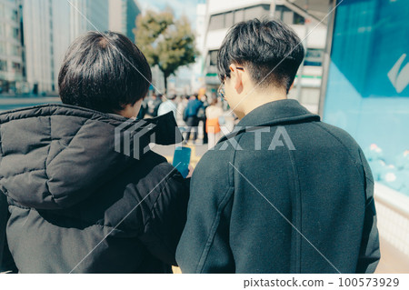 Photo of a male college student walking in the city 100573929