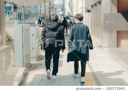 Photo of a male college student walking in the city 100573941
