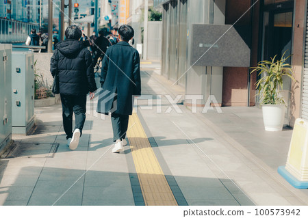 Photo of a male college student walking in the city 100573942