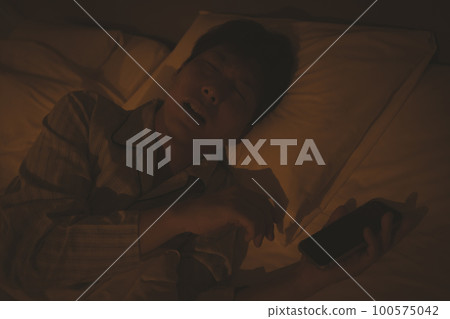 A man in his 40s sleeping with a bedroom and a smartphone 100575042
