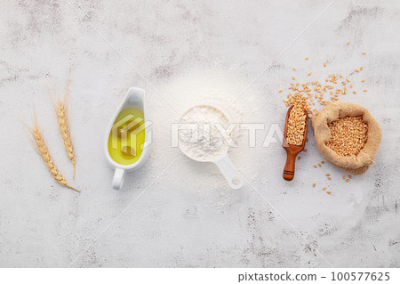 The ingredients for homemade pizza dough with wheat ears ,wheat flour and olive oil set up on white concrete background. top view and copy space. 100577625