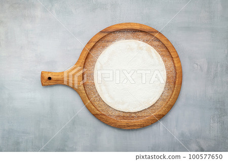 Empty wooden pizza platter set up on grey concrete. Pizza tray on grey concrete background flat lay and copy space. Empty wooden pizza platter set up on grey concrete. Pizza tray on grey concrete background flat lay and copy space. 100577650