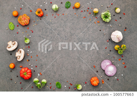 The ingredients for homemade pizza set up on dark stone background. 100577663