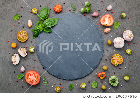 The ingredients for homemade pizza set up on dark stone background. The ingredients for homemade pizza set up on dark stone background. 100577680