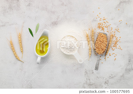 The ingredients for homemade pizza dough with wheat ears ,wheat flour and olive oil set up on white concrete background. top view and copy space. 100577695