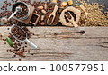 Background of various coffee , dark roasted coffee beans , ground and capsules with scoops setup on wooden background with copy space. 100577951