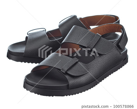 Beautiful pair of black leather flip-flops with two straps and additional heel fixation that stand, isolated on a white background. Hit of the season. 100578866