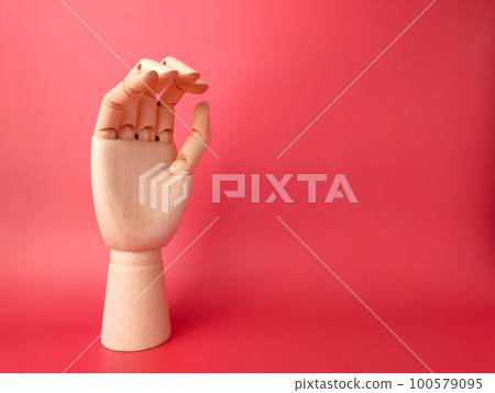 Wooden hand stand on a red background with copy space. Wooden hand stand on a red background with copy space. 100579095