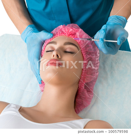 Plastic surgeon making an injection to his patient Plastic surgeon making an injection to his patient 100579598