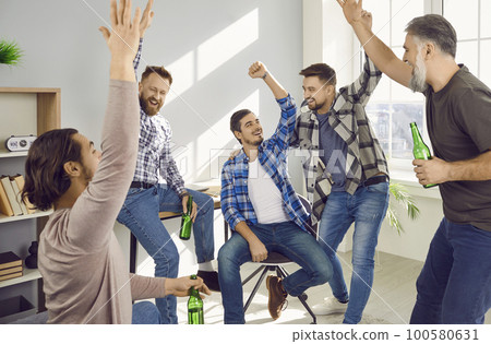Group of happy male friends celebrating meeting at home Group of happy male friends celebrating meeting at home 100580631