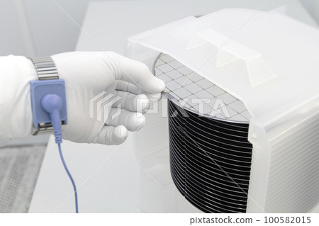 Gloved Hand Holding a Silicon Wafer in plastic holder box used in electronics for the fabrication of integrated circuits. Silicon wafer inspection. 100582015
