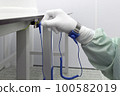 Bracelet on the hand of a man wearing ESD cloth and glove static resistance ESD bracelet or ground equipment, anti-static, used to safely ground is working. Semiconductor manufacturing. 100582019
